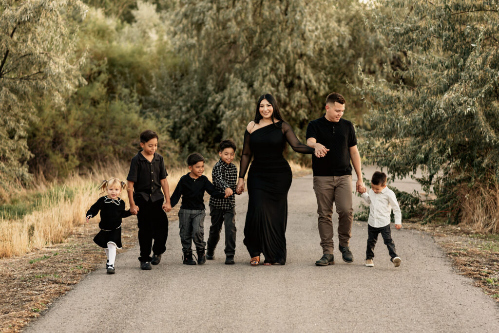 Lifestyle family photo with children laughing, holding hands, and walking