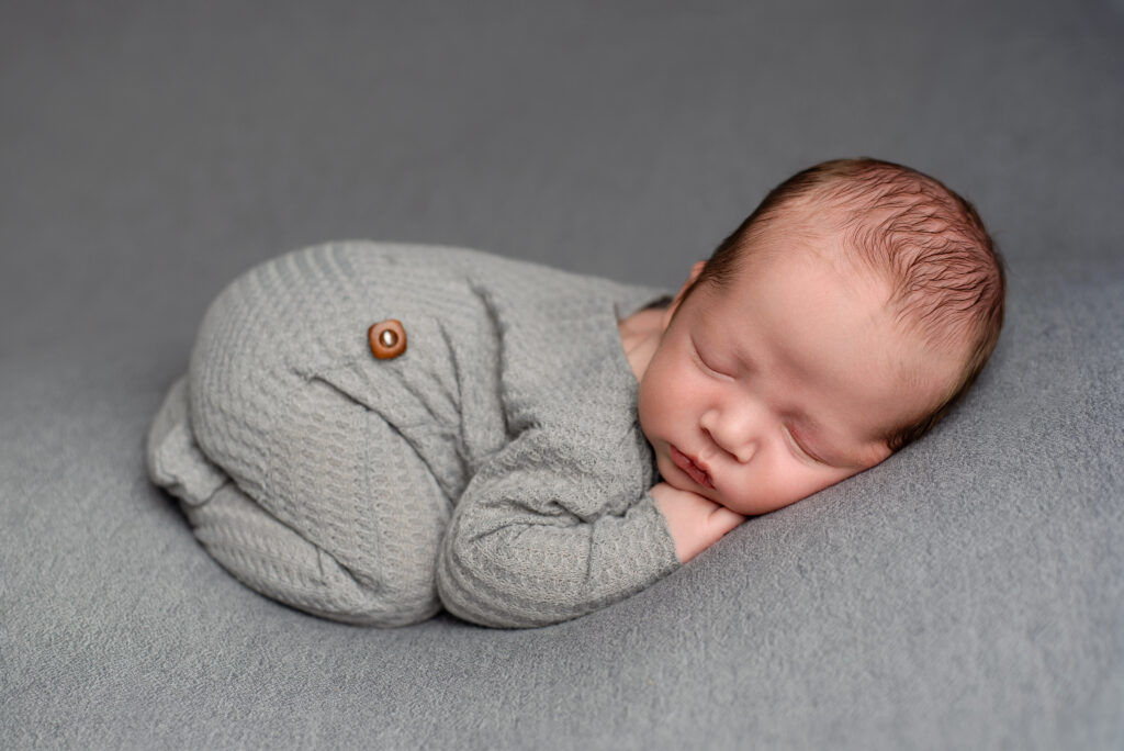 cute baby photo on grey with baby lying in a bum up pose