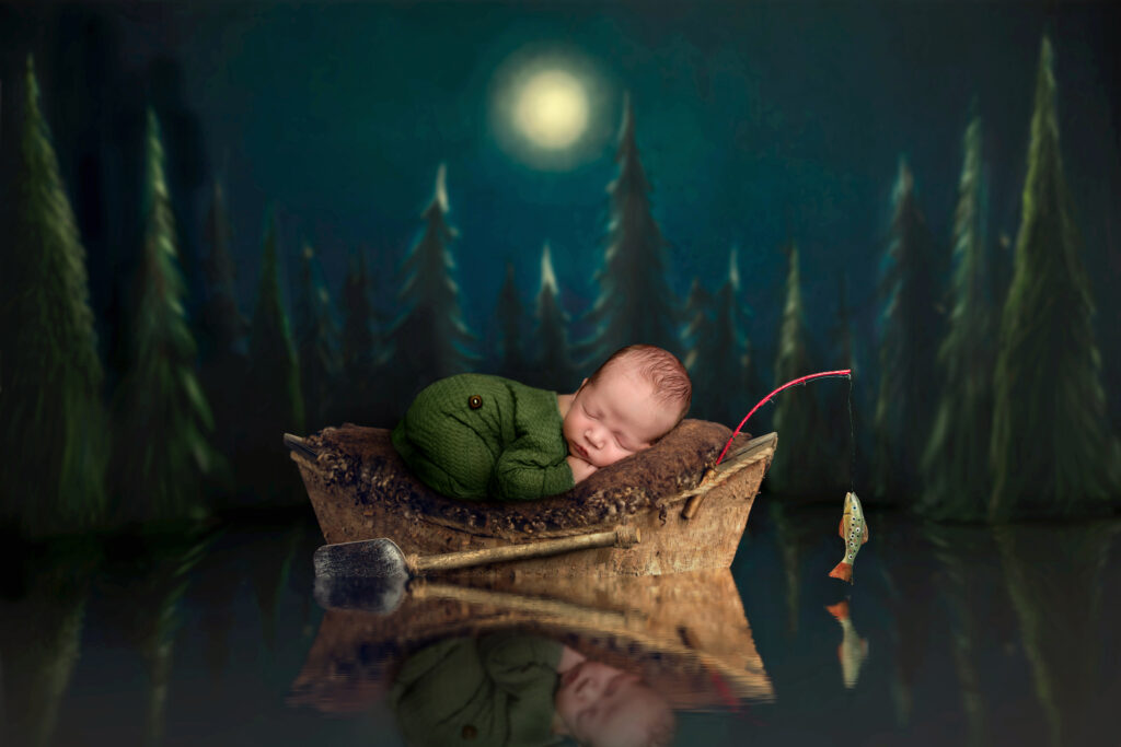 cute baby photo of newborn baby in a boat fishing at night in the mountains 